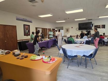 Wide view of the fellowship hall with buffet tables and church family at the Church BBQ 2026 — MLK Memorial Baptist Church