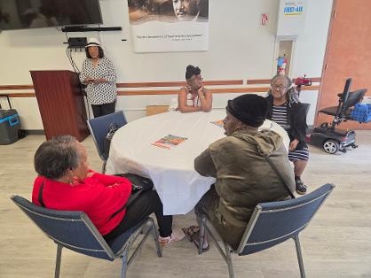 Church members gathered around a round table in conversation at the Church BBQ 2026 — MLK Memorial Baptist Church