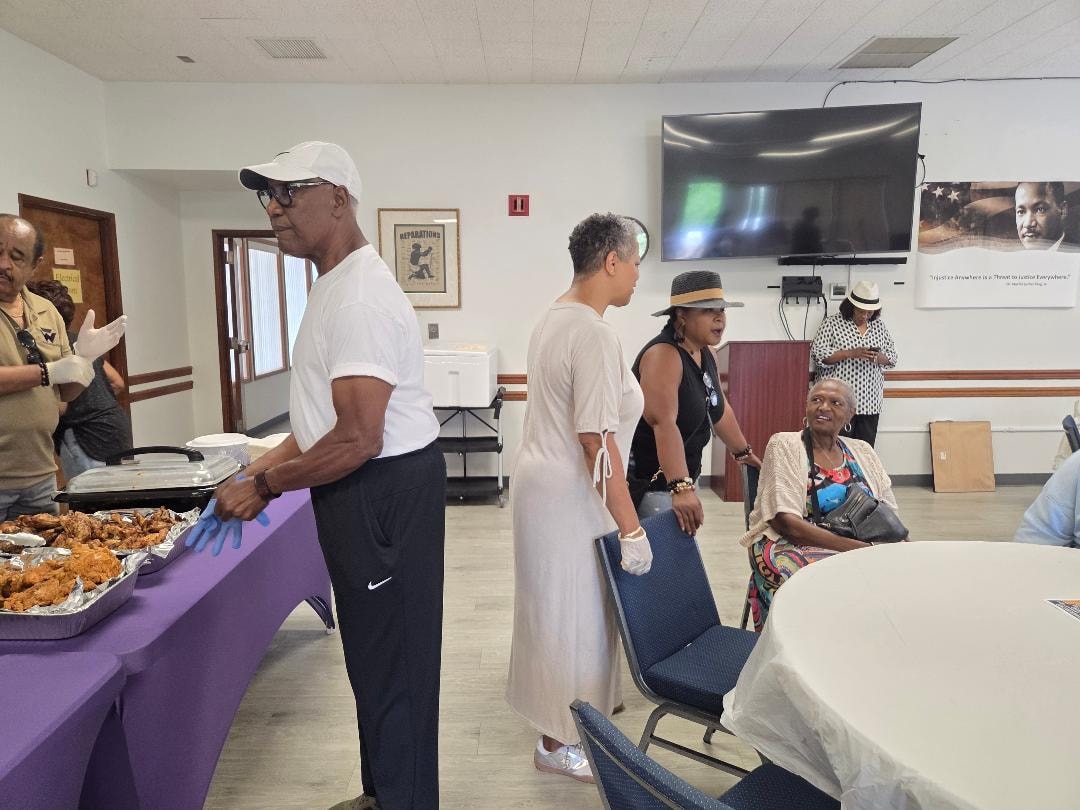 Church members gathering near the fried chicken buffet table at the Church BBQ 2026 — MLK Memorial Baptist Church