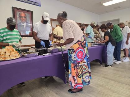 Bobbi and church members serving the congregation at the BBQ buffet line — MLK Memorial Baptist Church 2026