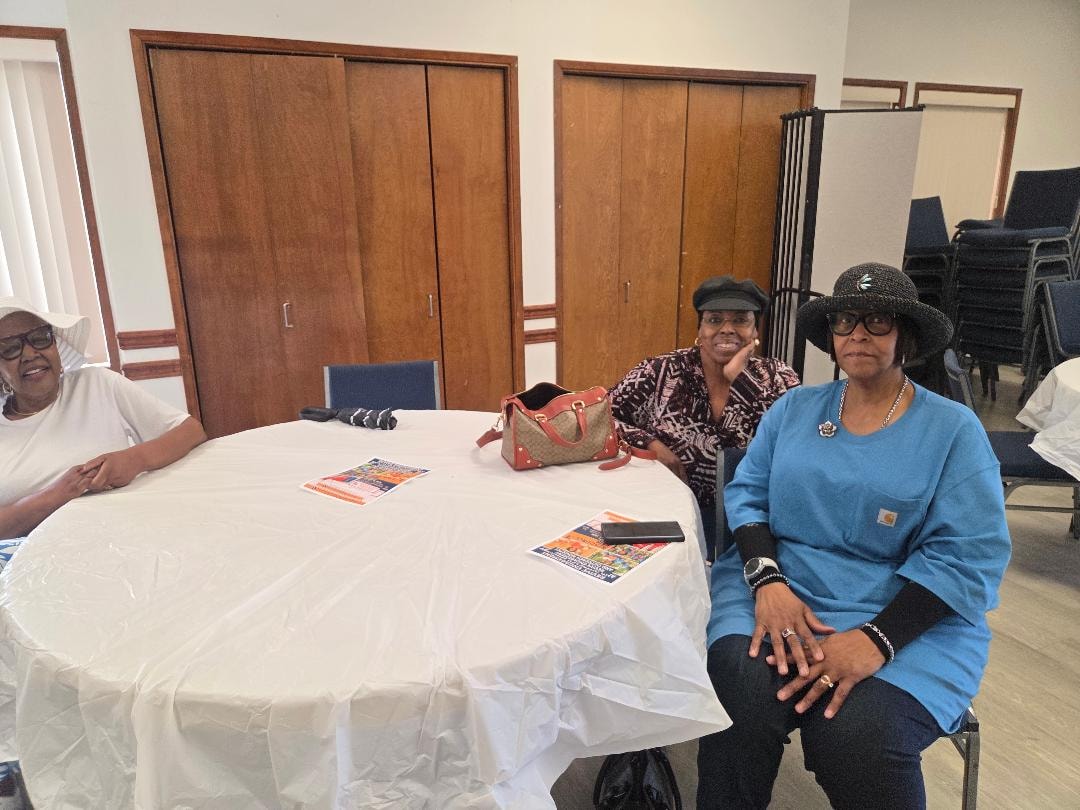 Carla and Linda seated at a round table at the Church BBQ 2026 — MLK Memorial Baptist Church