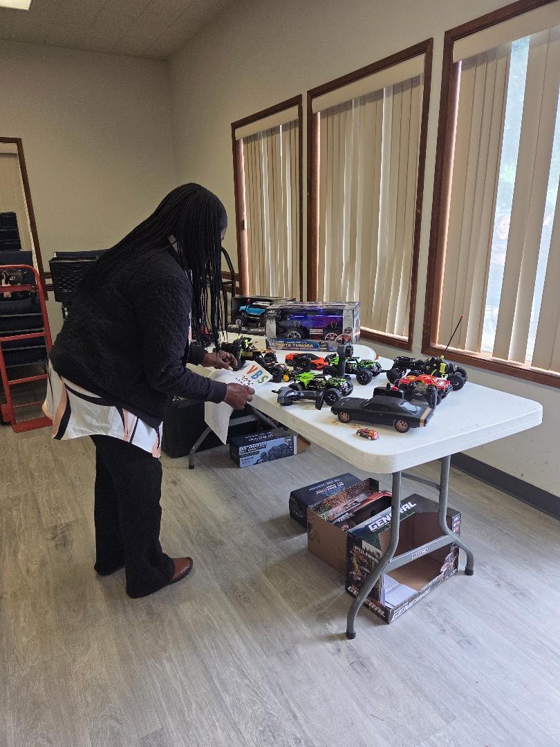 RC cars and toy vehicles on display table at the Church BBQ 2026 — MLK Memorial Baptist Church