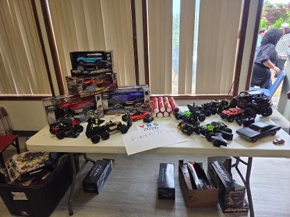 Close-up of RC cars and toy vehicles displayed on a table at the Church BBQ 2026 — MLK Memorial Baptist Church