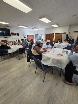 Church family and guests seated at round tables enjoying the BBQ fellowship — MLK Memorial Baptist Church 2026