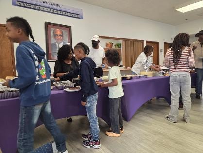 Children and adults filling their plates at the BBQ buffet — MLK Memorial Baptist Church 2026