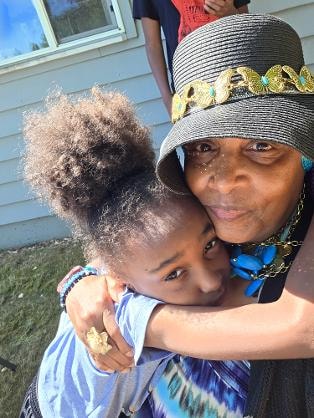 Grandmother and grandchild sharing a warm hug at the Church BBQ 2026 — MLK Memorial Baptist Church