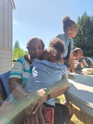 Family members embracing outdoors at the Church BBQ 2026 — MLK Memorial Baptist Church