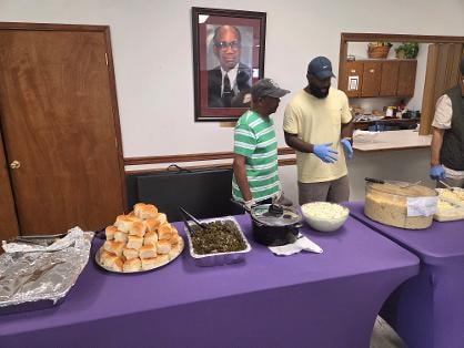 Kevin and Al serving at the purple buffet table at the Church BBQ 2026 — MLK Memorial Baptist Church
