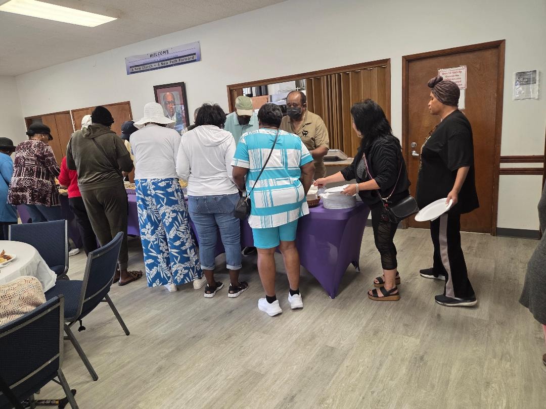 Church members lining up at the purple-draped buffet table at the Church BBQ 2026 — MLK Memorial Baptist Church