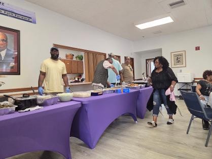 Long serving line with church members dishing up BBQ plates — MLK Memorial Baptist Church 2026