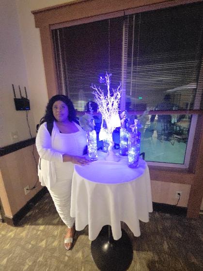 Guest in white dress standing beside illuminated centerpiece table at the Golden Jubilee All-White Affair — MLK Memorial Baptist Church 2026