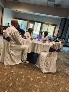 Church members gathered at a table in white attire at the Golden Jubilee All-White Affair — MLK Memorial Baptist Church 2026