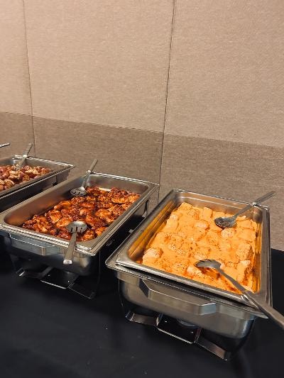 Catering buffet trays with chicken and mac and cheese at the Golden Jubilee All-White Affair — MLK Memorial Baptist Church 2026