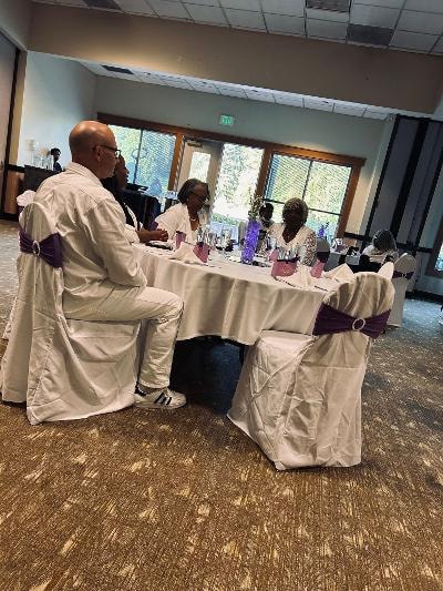 Guests seated at the head table with white linens and purple sash chairs at the Golden Jubilee All-White Affair — MLK Memorial Baptist Church 2026
