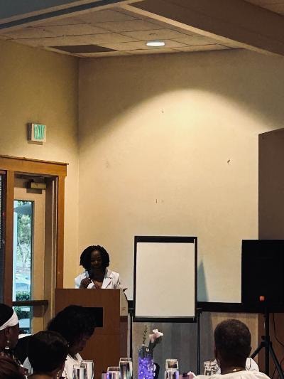 Speaker at the podium addressing guests at the Golden Jubilee All-White Affair — MLK Memorial Baptist Church 2026