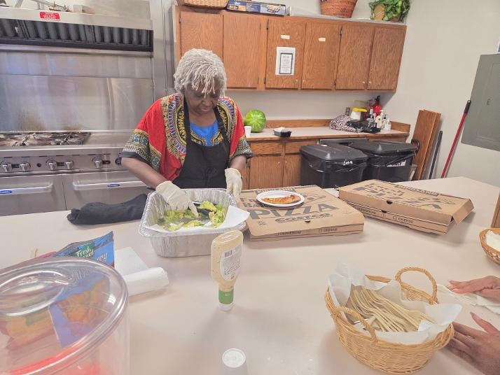 Laura fixing salad — VBS Day 2 fellowship dinner