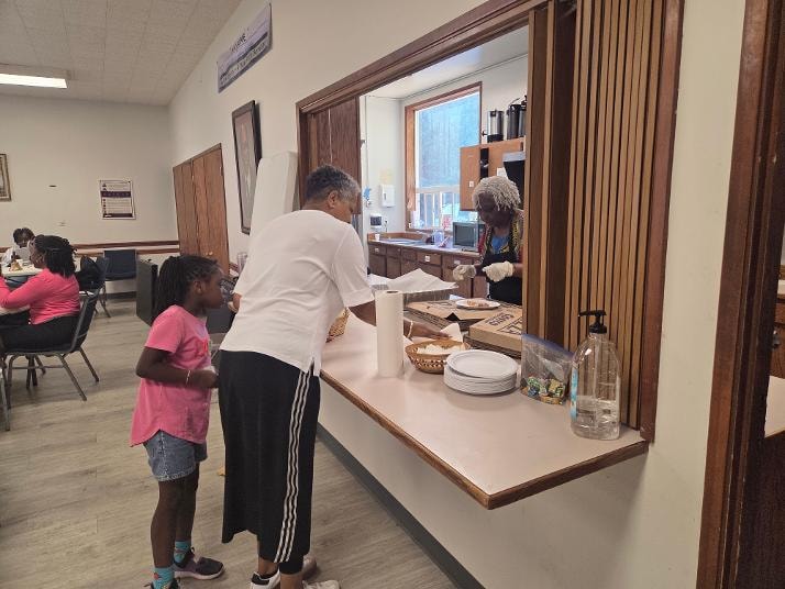 Sharon serving at the kitchen window — VBS Day 2