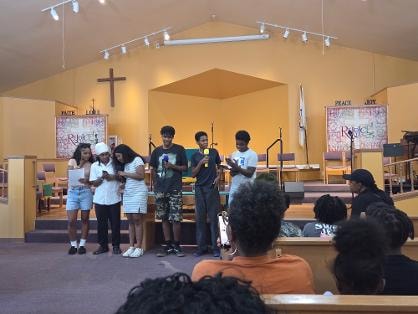 Youth group performing at the front of the sanctuary — VBS Day 3 Assembly