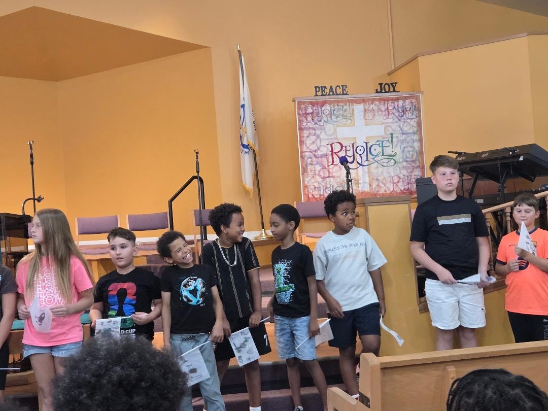 Children lined up on stage in the sanctuary during VBS Day 3 Assembly — MLK Memorial Baptist Church