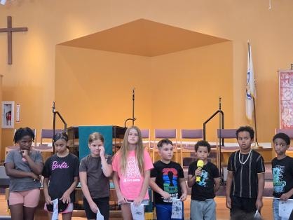 Children lined up on stage at the sanctuary — VBS Day 3 Assembly