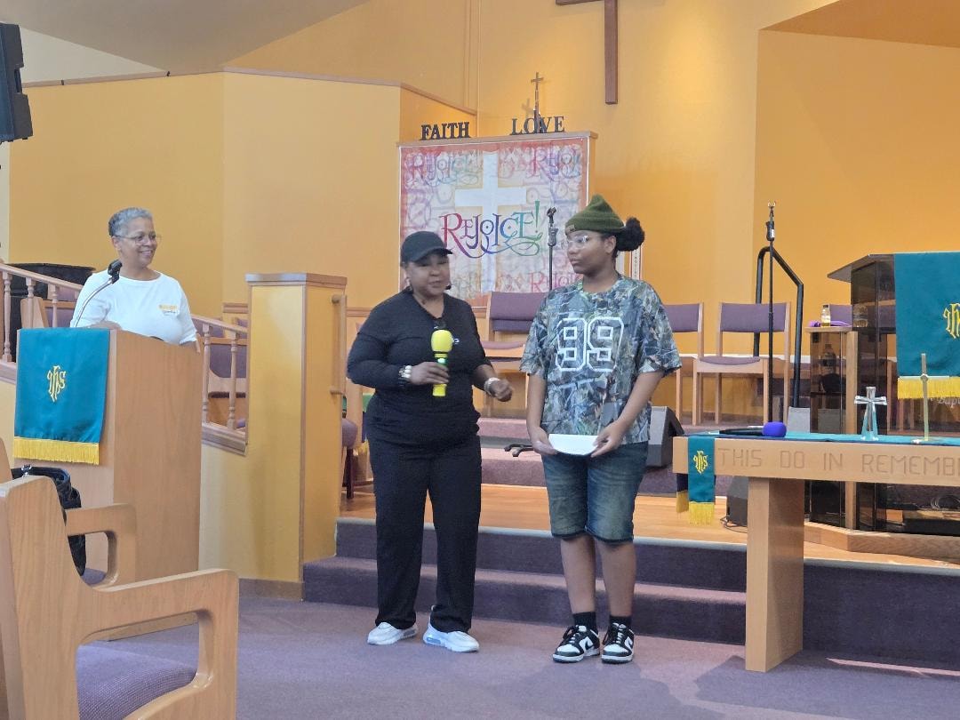 Adult with youth at the sanctuary podium — VBS Day 3 Assembly
