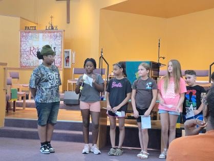 Youth group on stage at the sanctuary — VBS Day 3 Assembly