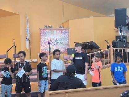 Children on stage at the sanctuary during VBS Day 3 Assembly — MLK Memorial Baptist Church