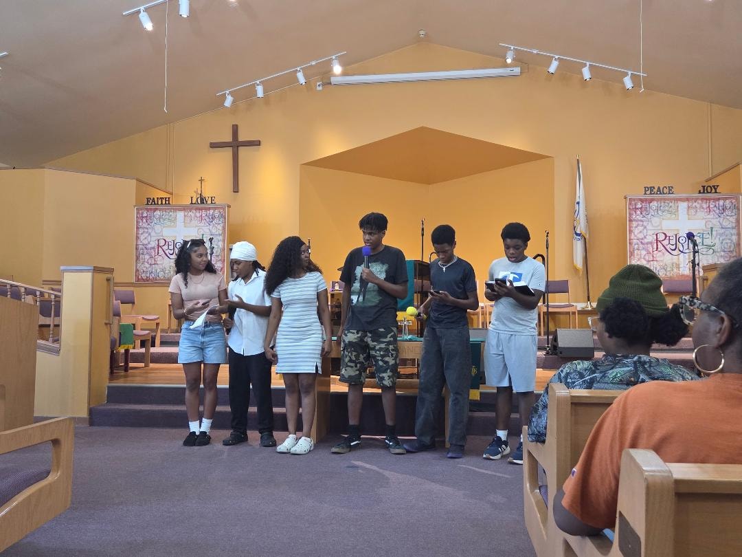 Youth group presenting on stage in the sanctuary — VBS Day 3 Assembly, MLK Memorial Baptist Church