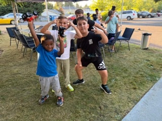 Children celebrating with toy cars outdoors — VBS Day 3 Assembly