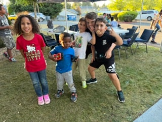 Group of children posing together on the grass — VBS Day 3 Assembly