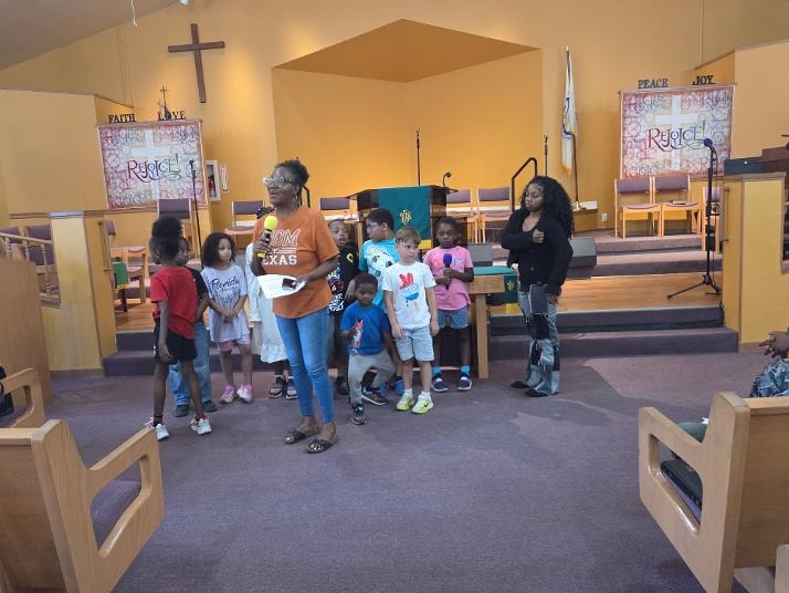Kim leading children in the sanctuary during VBS Day 3 Assembly — MLK Memorial Baptist Church
