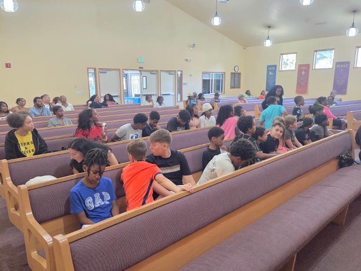 Children seated in pews during VBS Day 3 Assembly — MLK Memorial Baptist Church