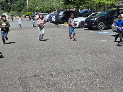 Two men talking in parking lot during outdoor event — VBS Day 3 Assembly