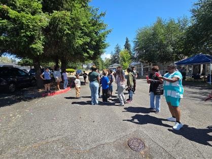 Two people high-fiving at outdoor VBS event — VBS Day 3 Assembly