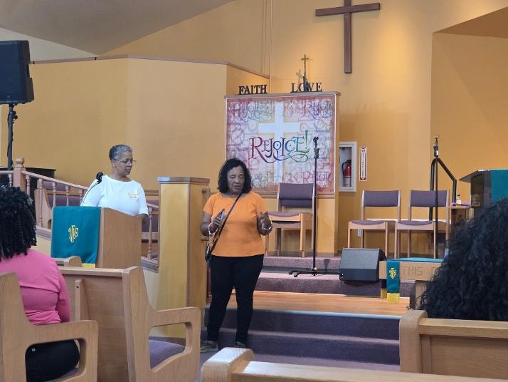 Sharon and Linda speaking at the sanctuary podium — VBS Day 3 Assembly